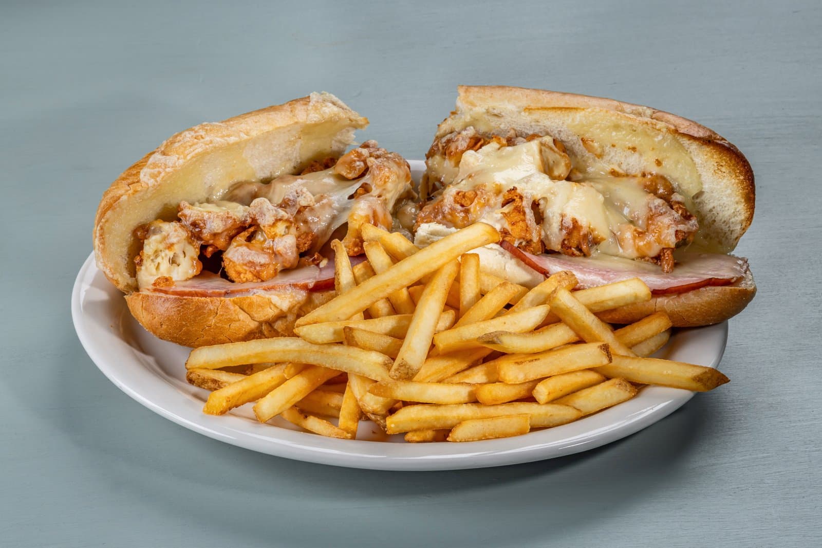 Crispy chicken sub with melted cheese and fries