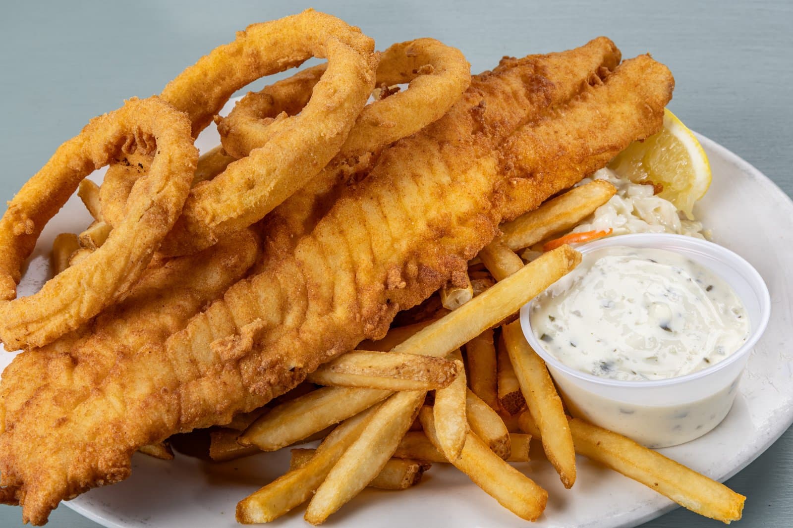 Golden fried fish and chips with onion rings and tartar sauce