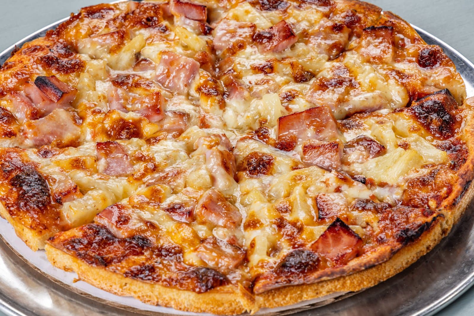 Hawaiian pizza with ham and pineapple, fresh out of the oven