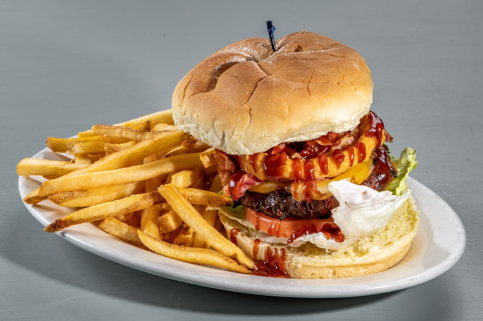 The Smoke House Burger stacked with bacon, onion rings, and BBQ sauce